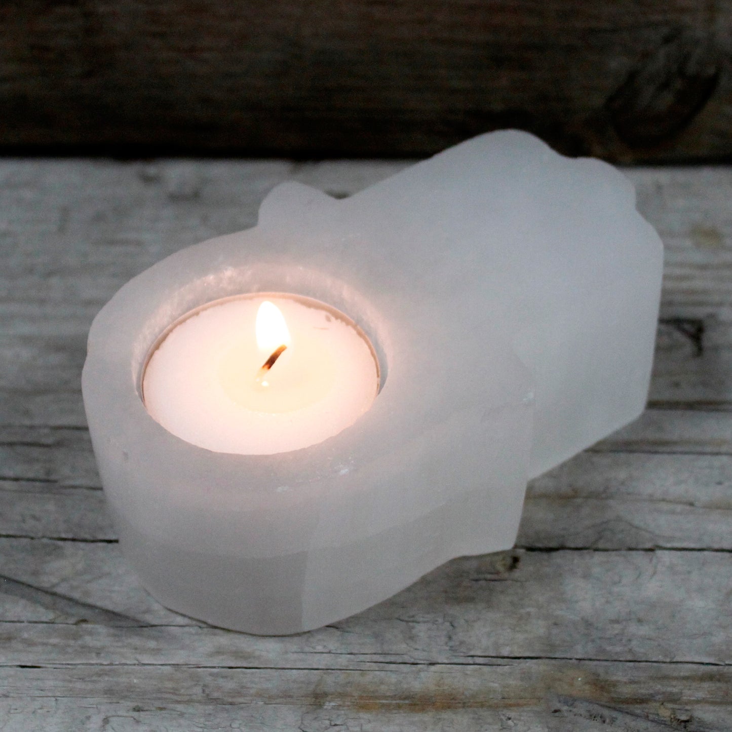 Selenite Hamsa Candle Holder. Size: width 10cm, Lengh 6.5cm, Height 3.5cm.